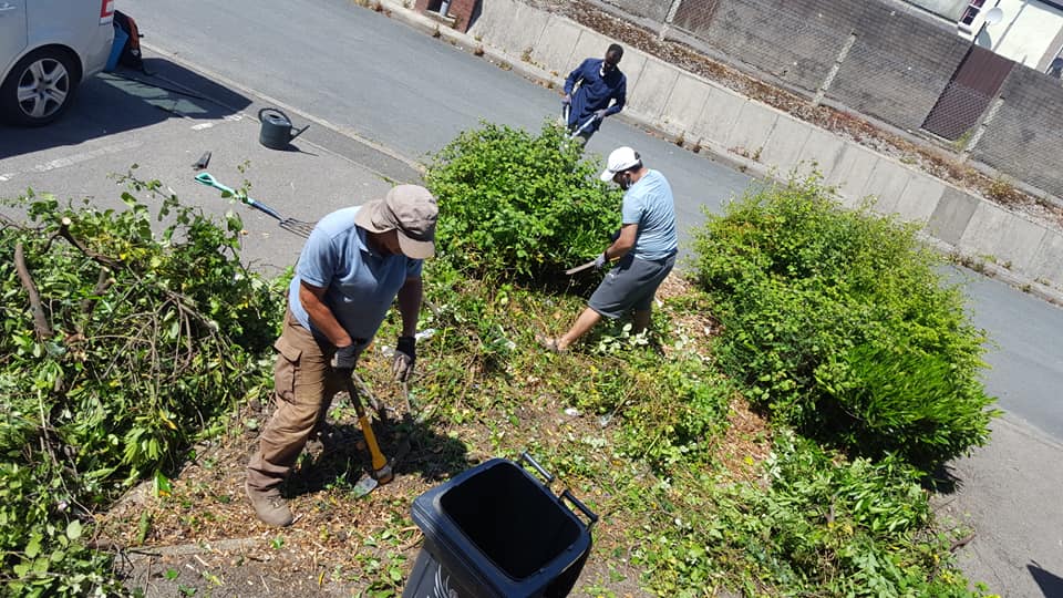three men gardening on a side street