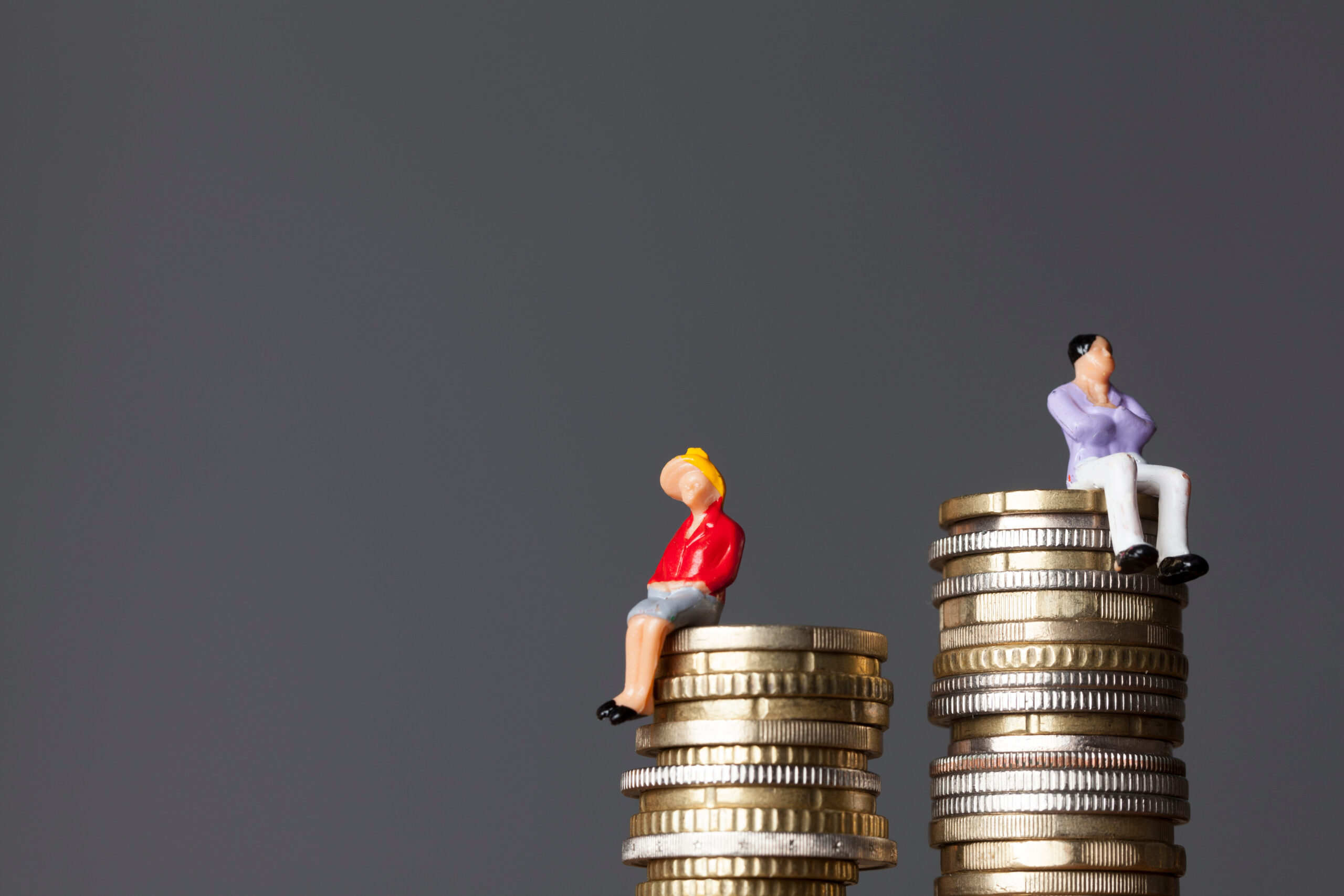 Gender pay equality concept. man and woman on a stack of coins.